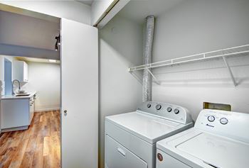 A white washing machine and dryer in a small laundry room